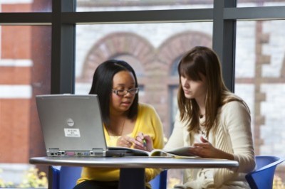 Two female students Sitting at Table discussing thermodynamics